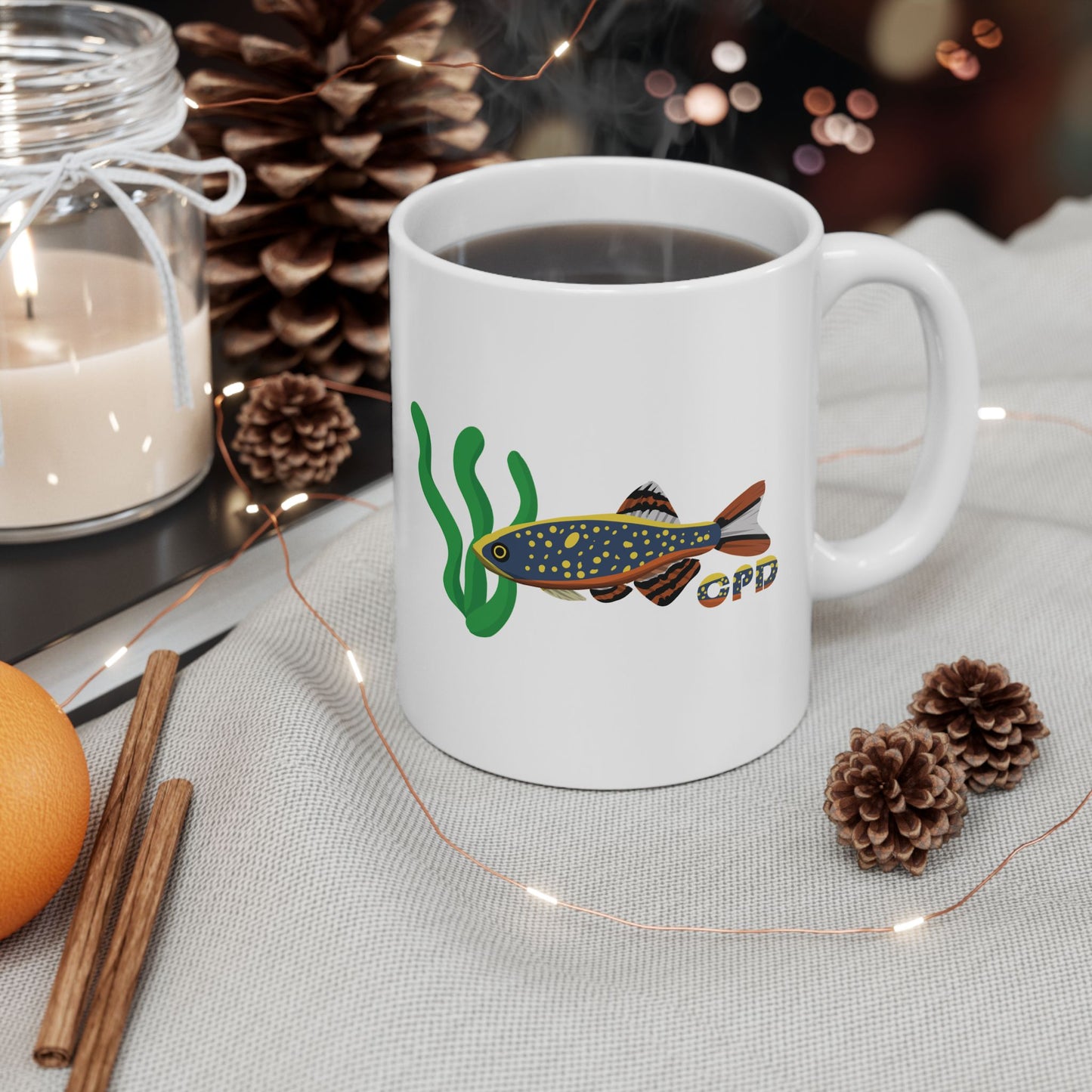 White Celestial Pearl Danio mug with fish design filled with coffee on a cozy table