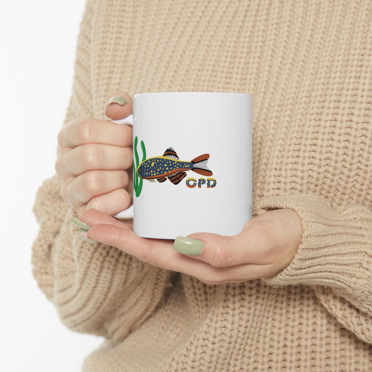 White Celestial Pearl Danio mug featuring colorful fish design held by person in beige sweater