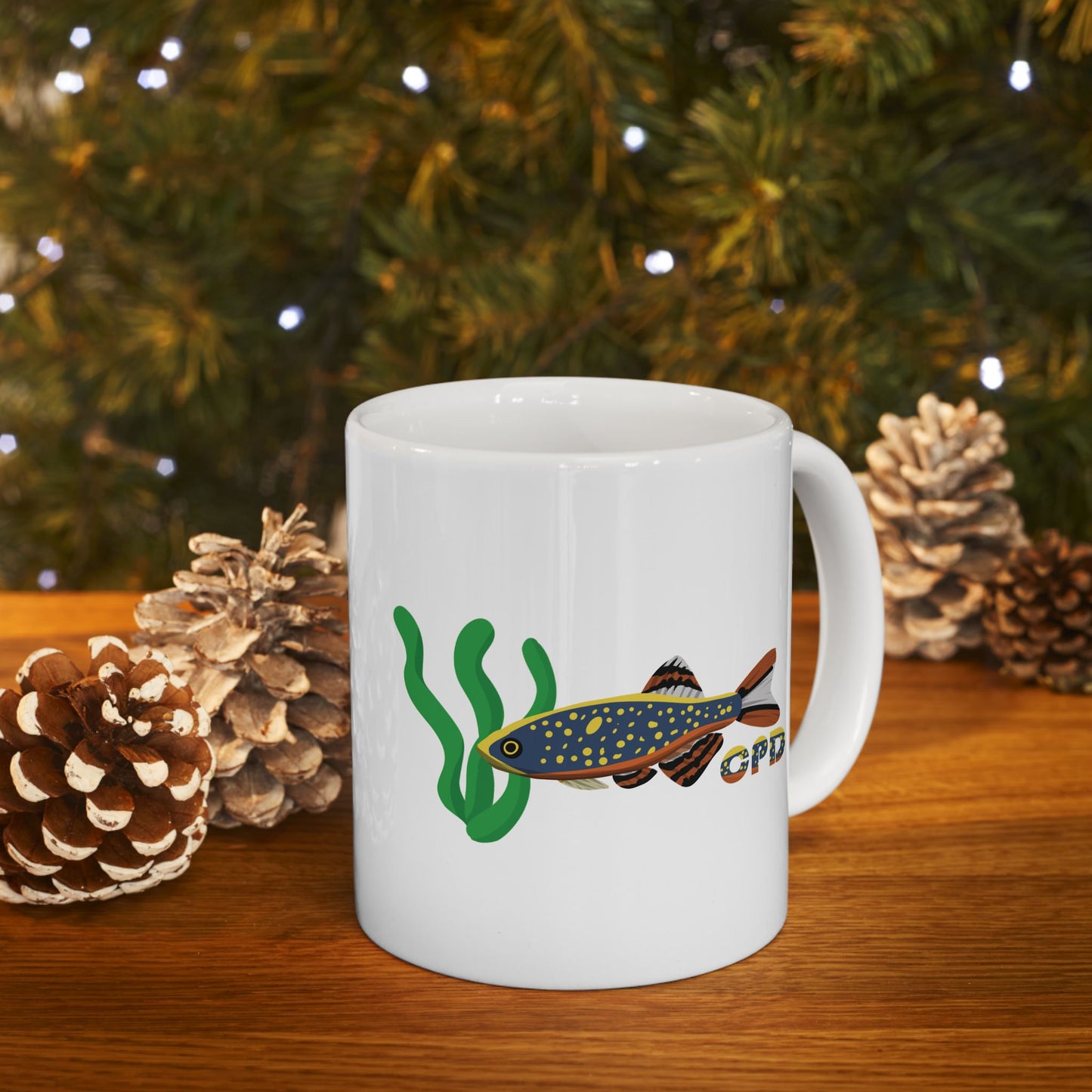 White Celestial Pearl Danio mug with fish and aquatic plant design on wooden table with pine cones