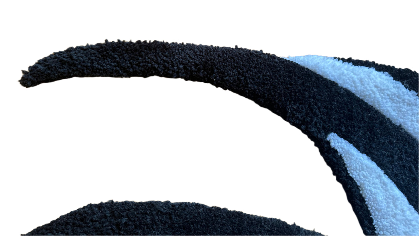 Close-up of Scallywag's Fish Bowl handmade angelfish rug featuring black and white textured fibers