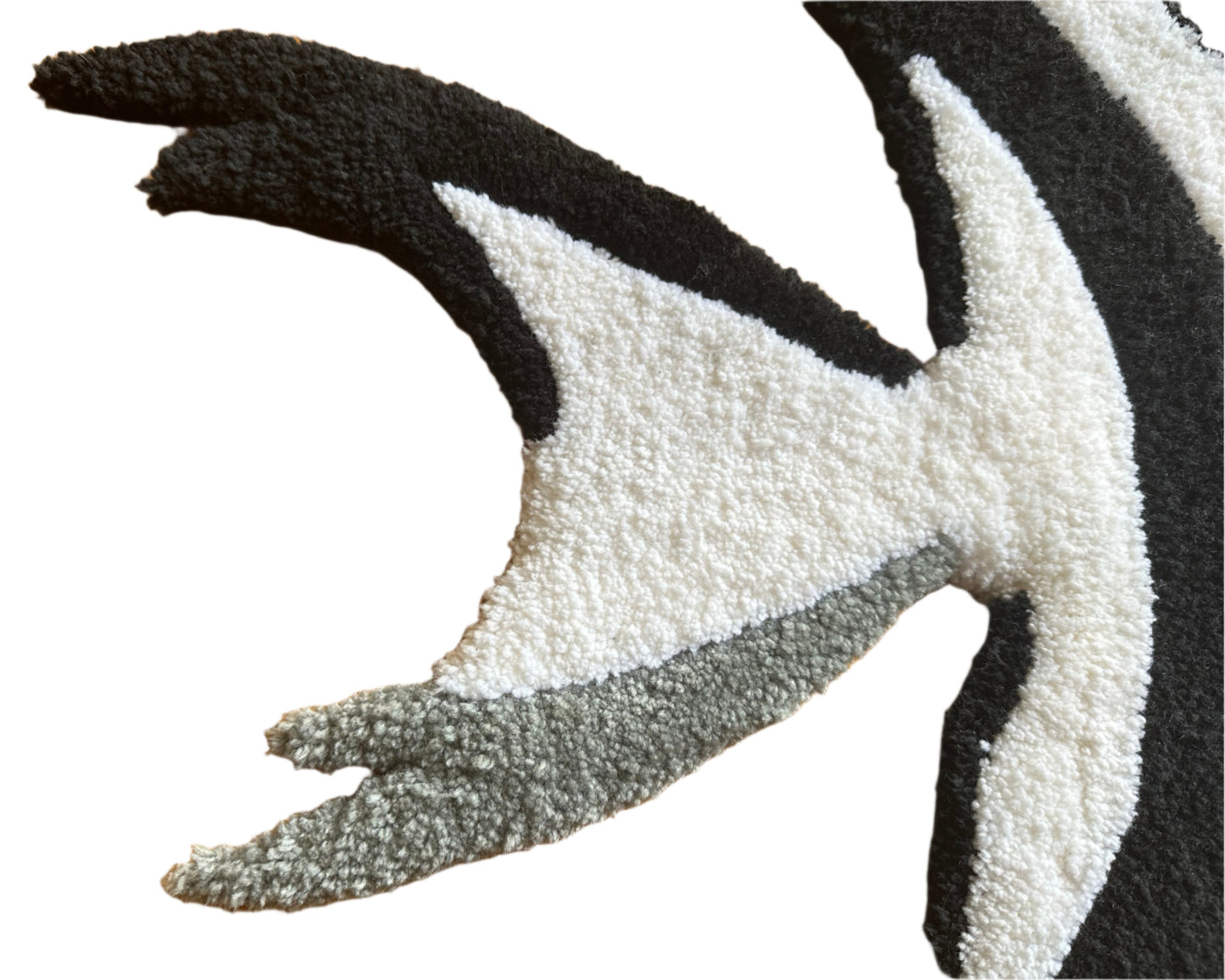 Close-up of handmade angelfish rug showing textured black white and gray tufted details