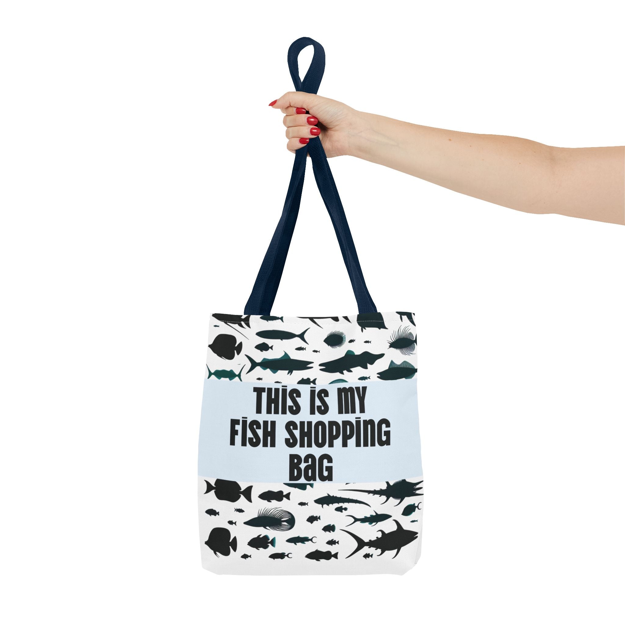 Tote bag with fish design and text 'This is my fish shopping bag' held by a hand.