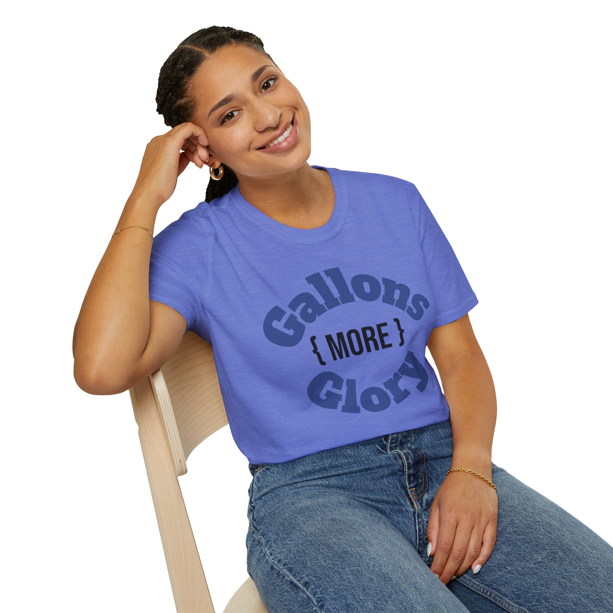 Smiling woman sitting in chair wearing blue “More Gallons More Glory” shirt