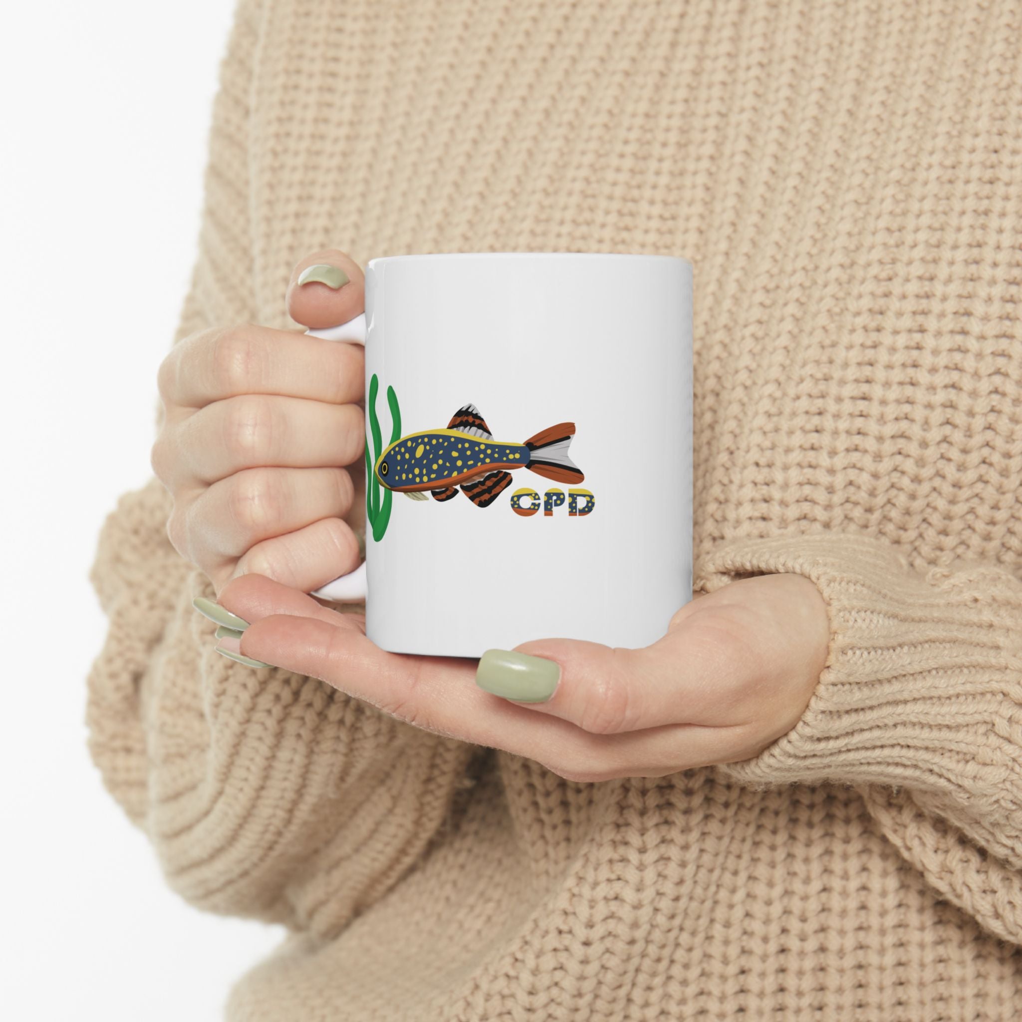 White Celestial Pearl Danio mug featuring colorful fish design held by person in beige sweater