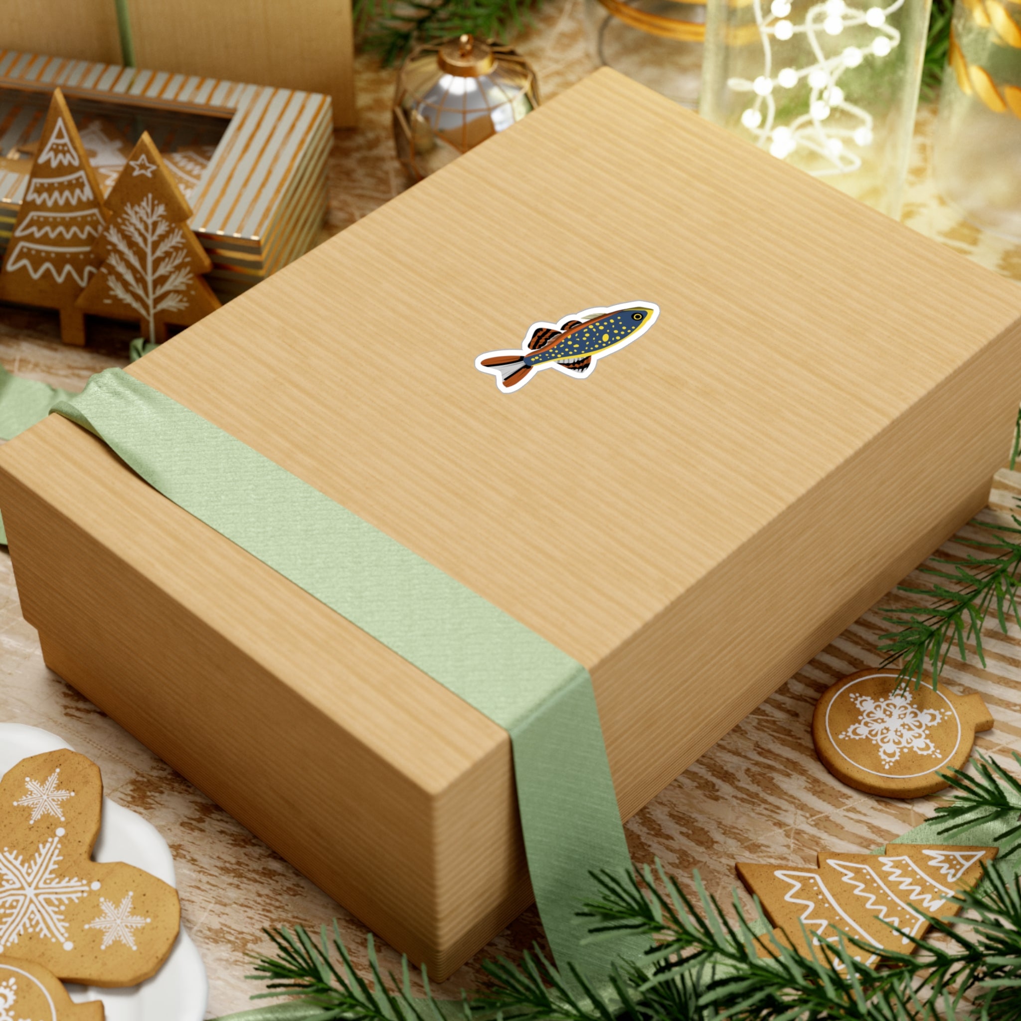 Celestial Pearl Danio sticker on a gift box with green ribbon surrounded by Christmas cookies and decorations