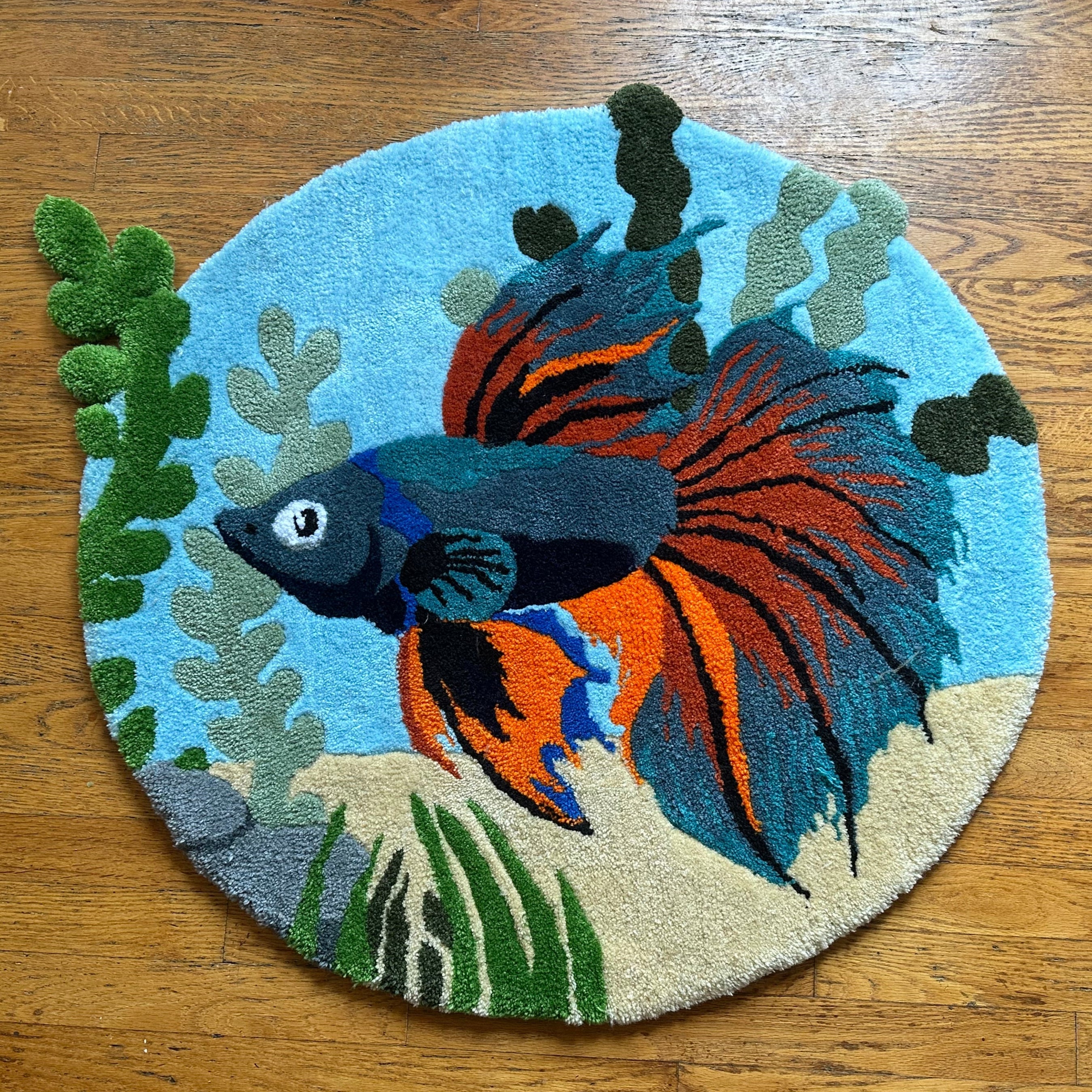 Scallywags Fish Bowl handmade betta fish rug with vibrant orange and blue fish design on round blue background