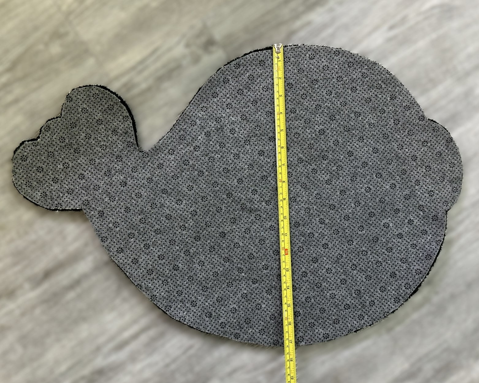 Backside view of Scallywag's Fish Bowl cute fish rug with measurement tape on gray floor