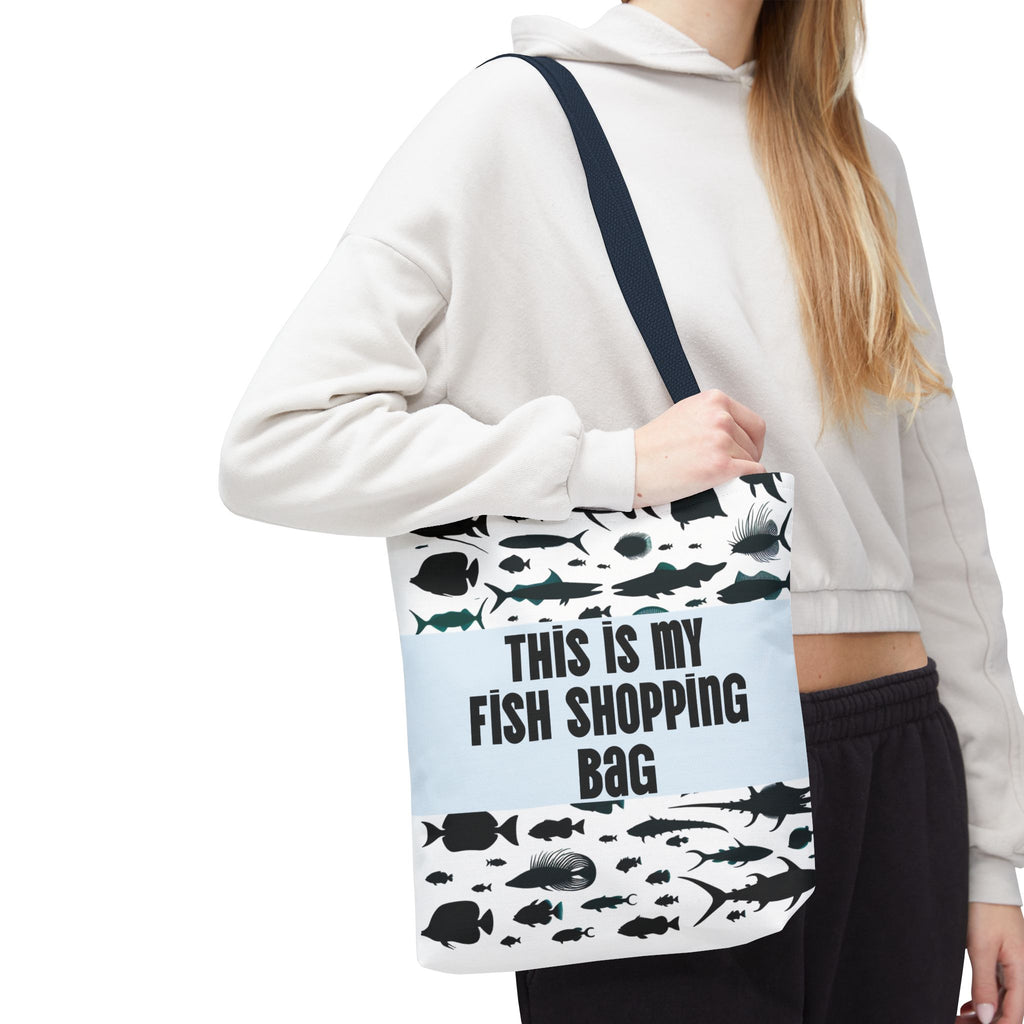 Person wearing a tote bag with fish designs and text on a white background