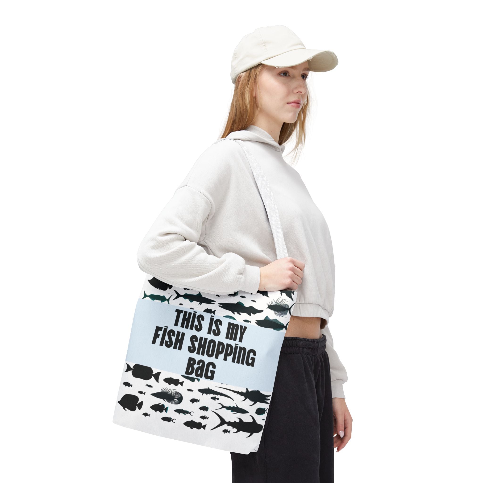 Person holding a tote bag with fish designs and text on a white background