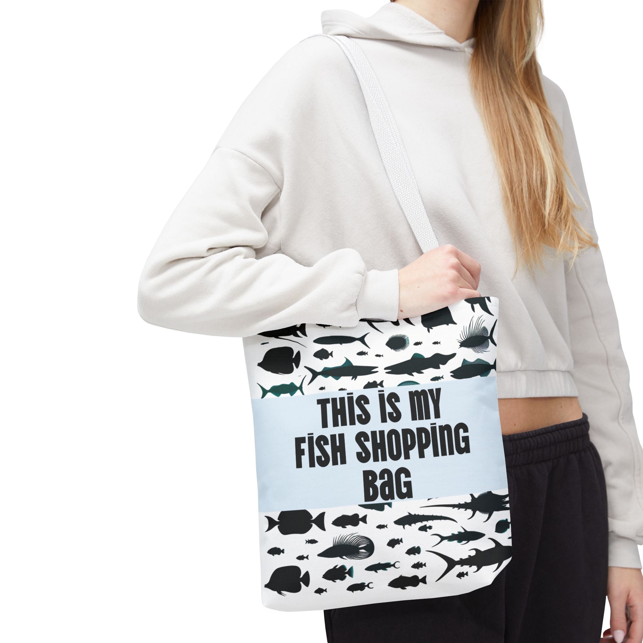Funny fish-themed tote bag with black fish silhouettes and bold text carried by a woman in casual outfit