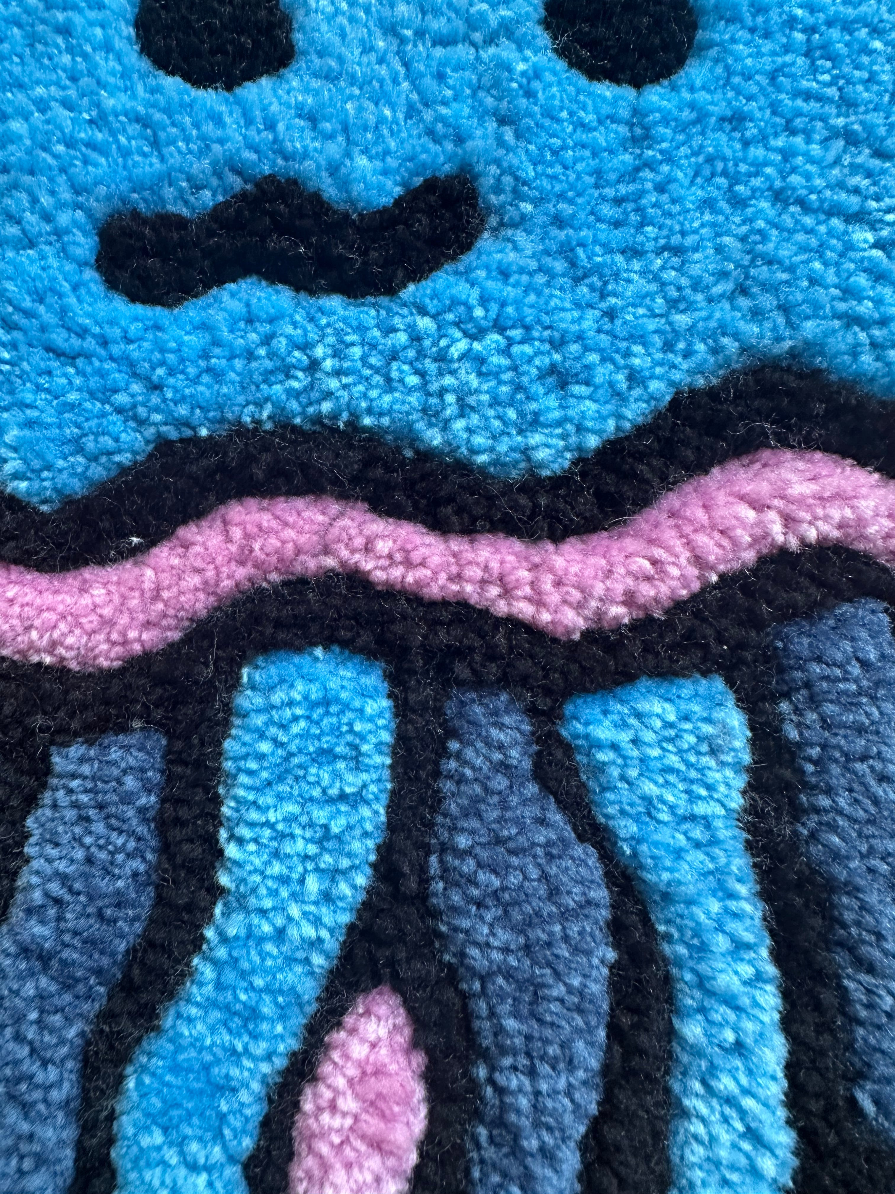 Close-up of Scallywag's Fish Bowl handmade jellyfish rug with blue, pink, black, and gray details