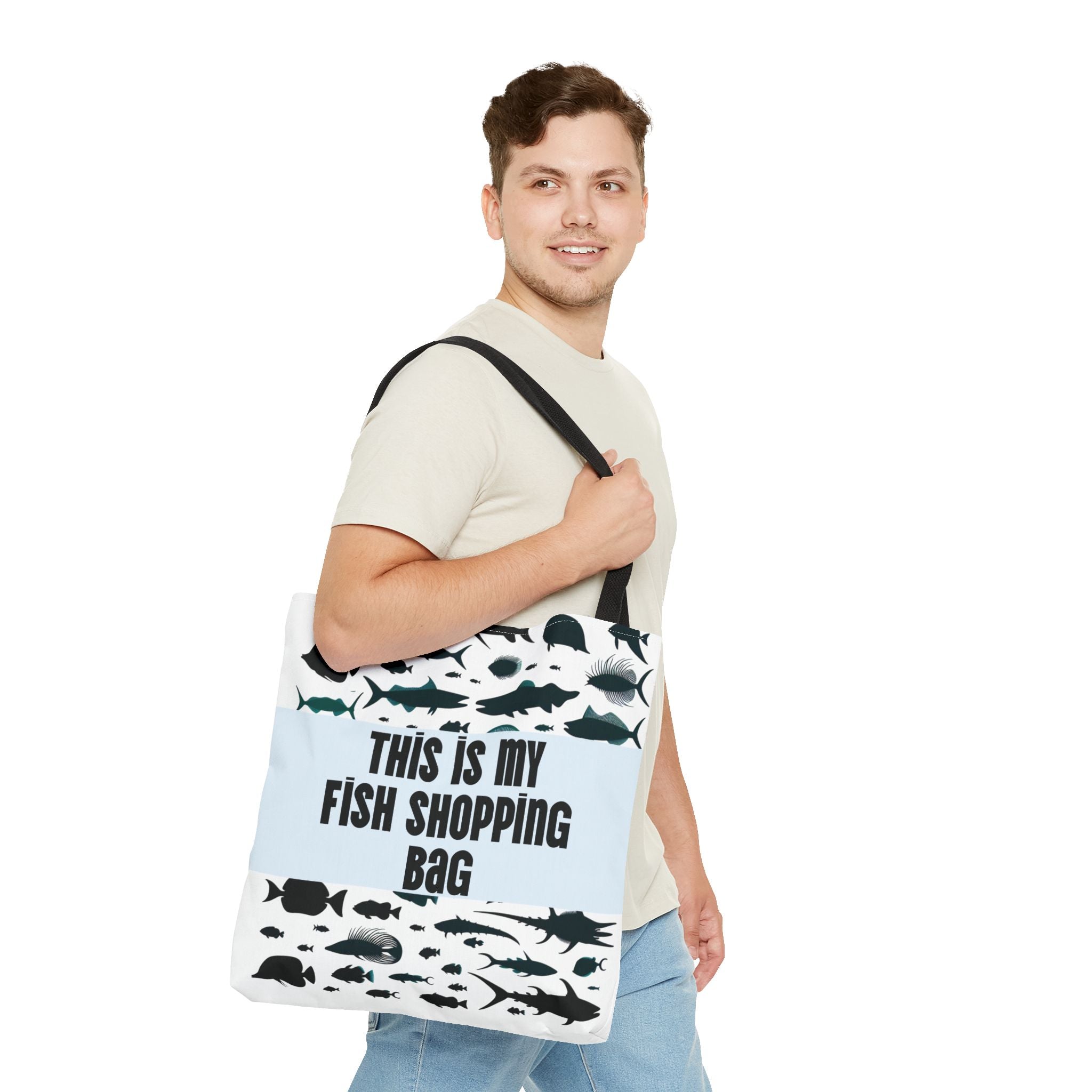 Man holding a tote bag with fish designs and text on a white background