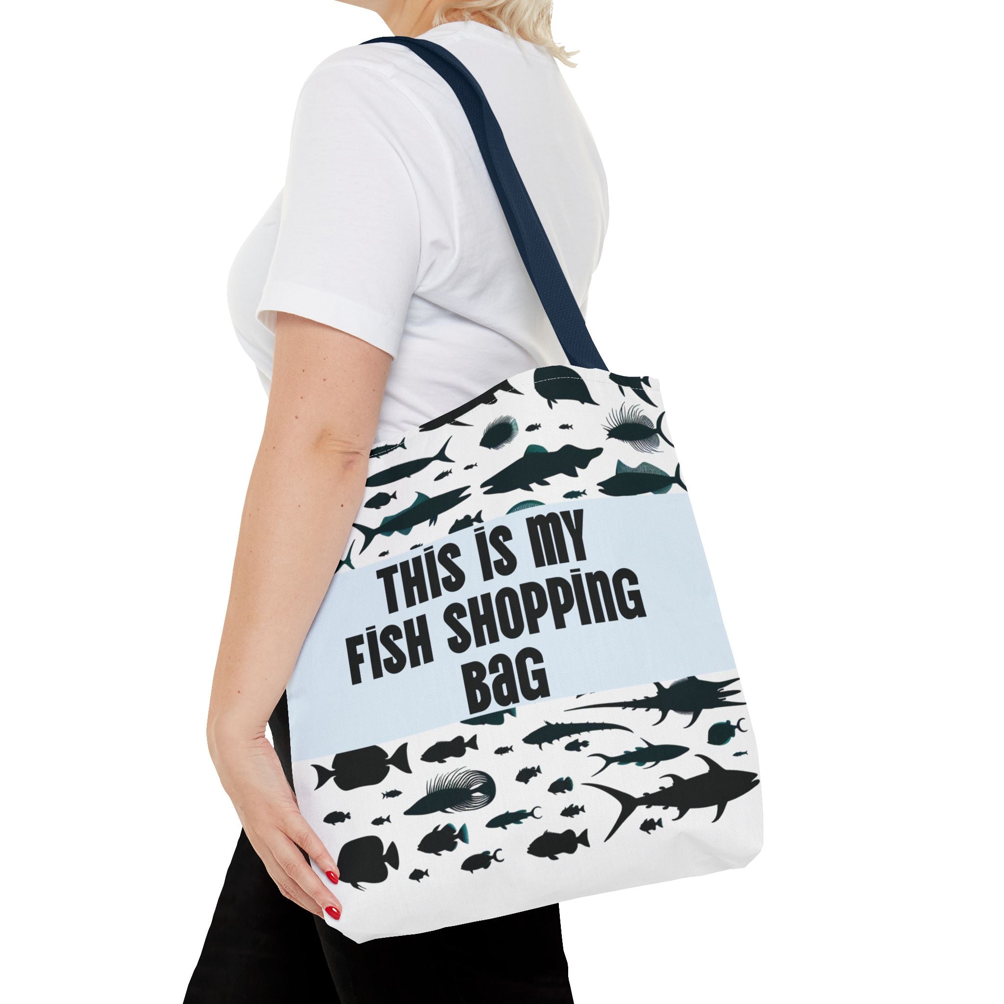 Person holding a tote bag with fish designs and text on a white background