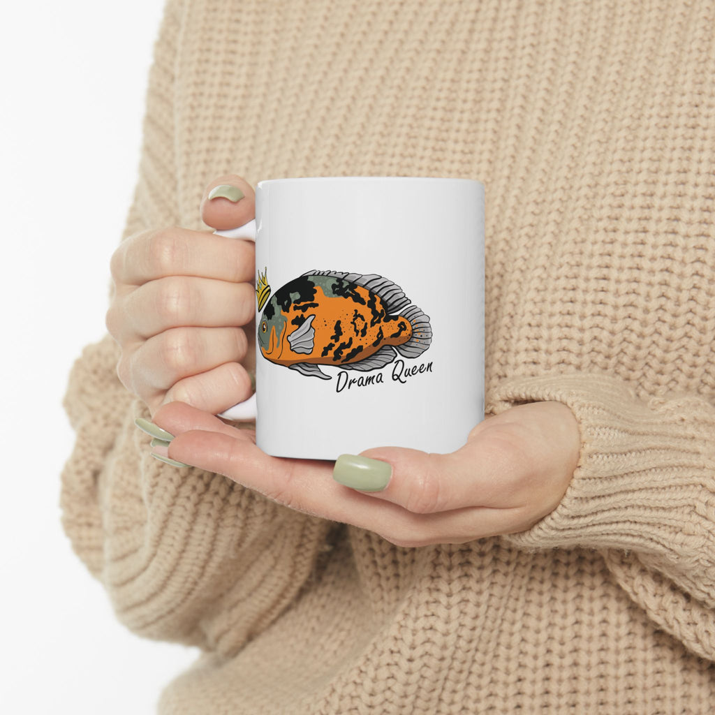 Oscar fish mug gift with colorful fish design and Drama Queen text held by person in beige sweater