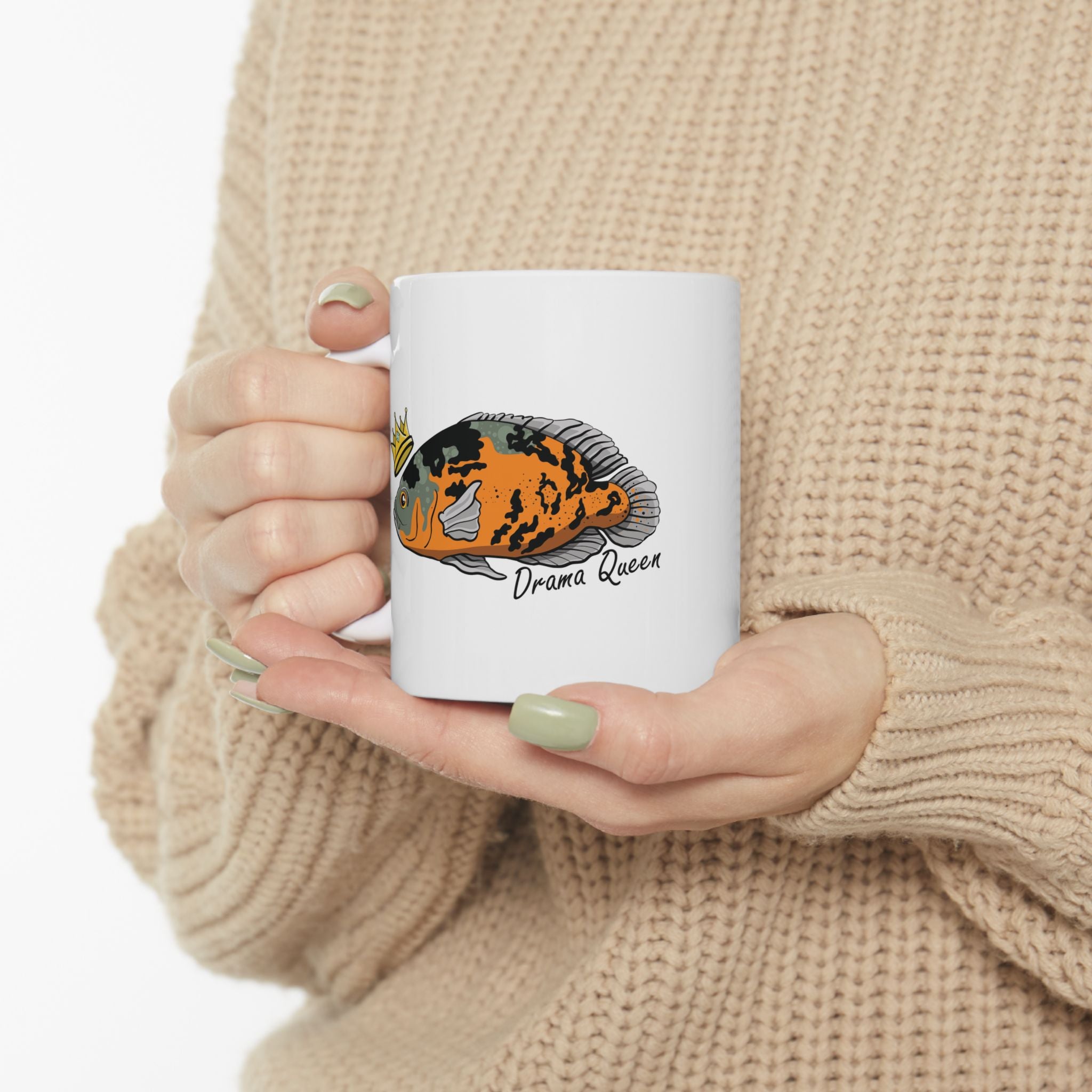 Oscar fish mug gift with colorful fish design and Drama Queen text held by person in beige sweater
