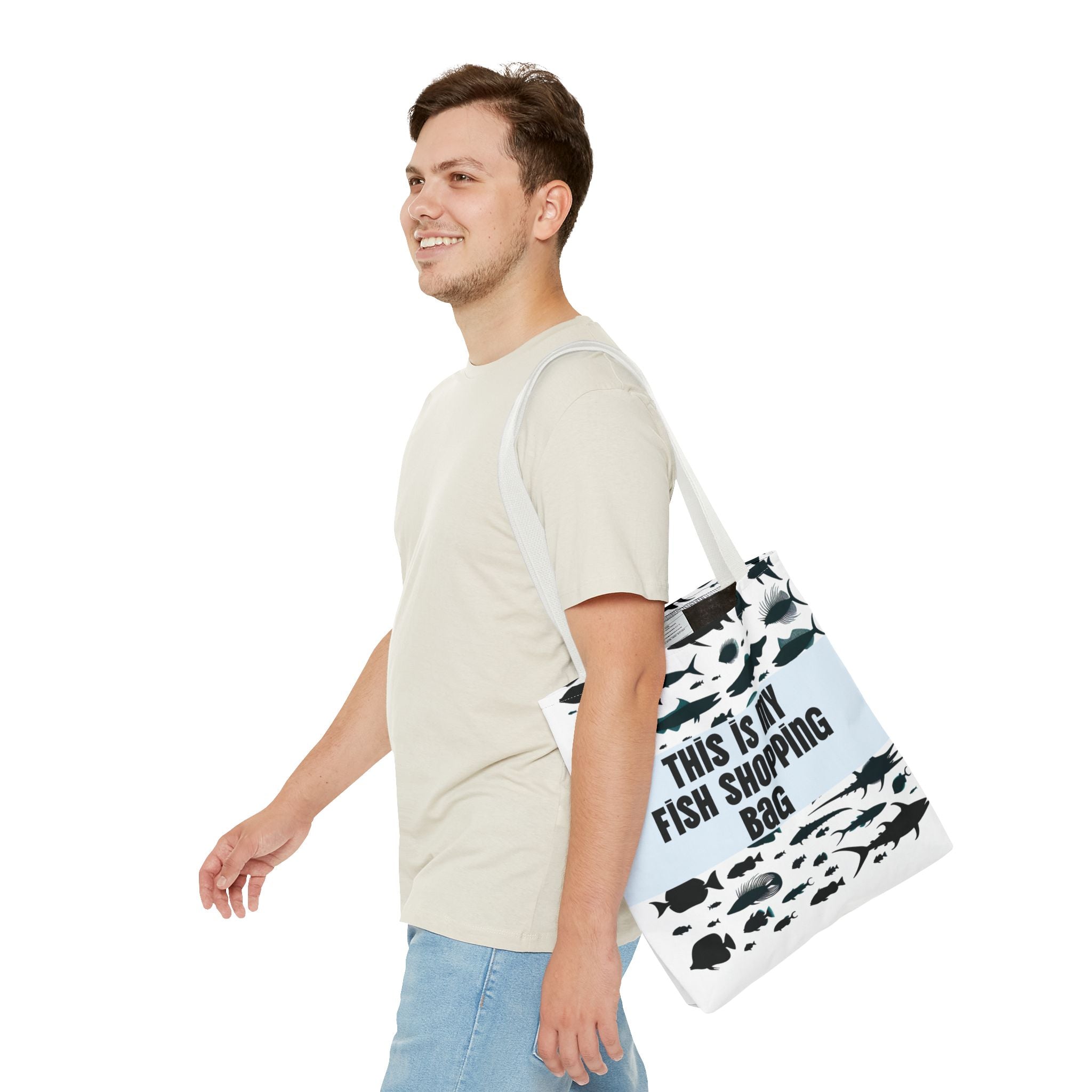 Man carrying a white tote bag with black fish illustrations and text on a white background