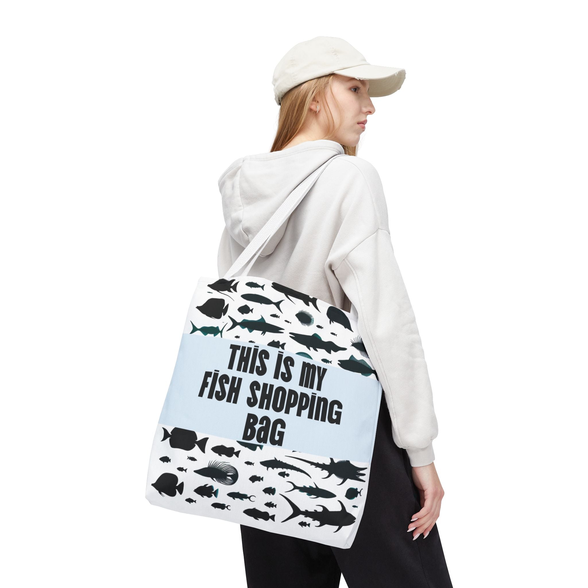 Person wearing a tote bag with fish designs and text on a white background