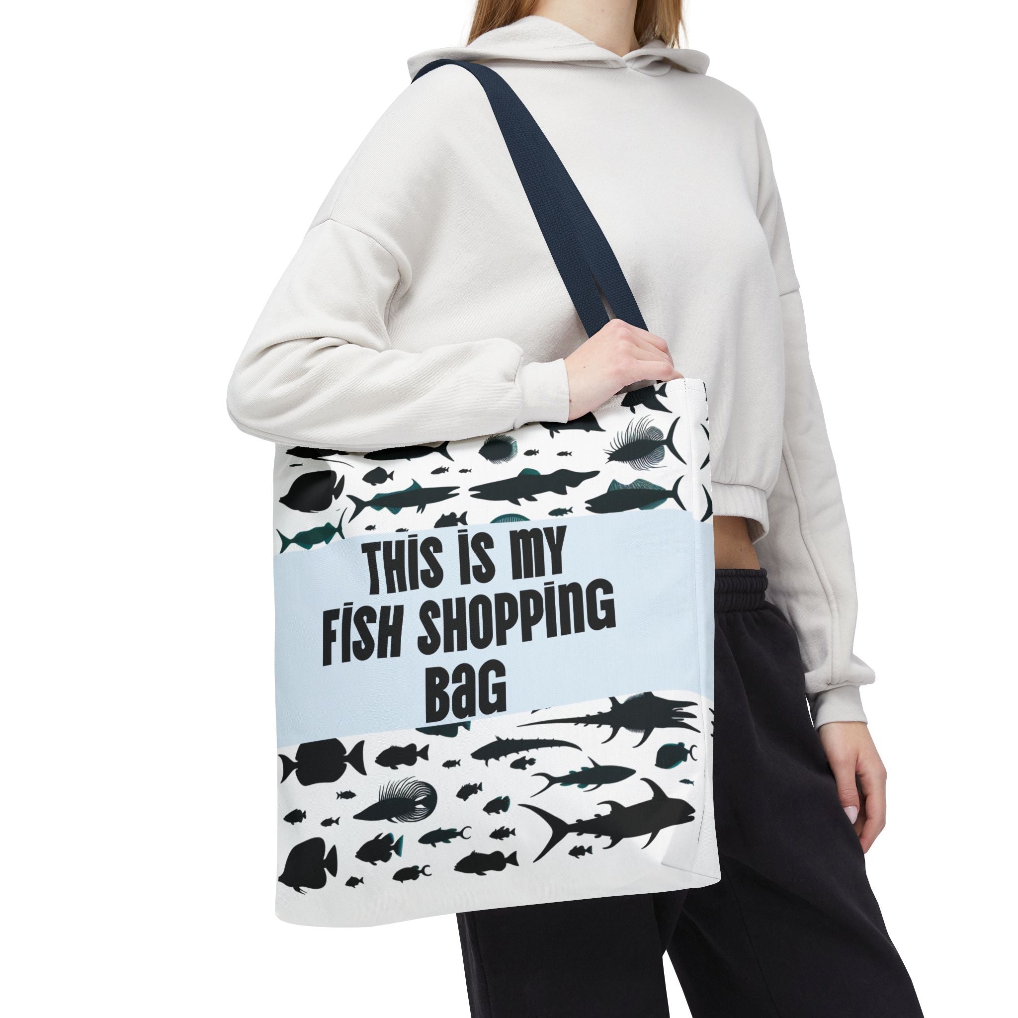 Person wearing a tote bag with fish designs and text on a white background