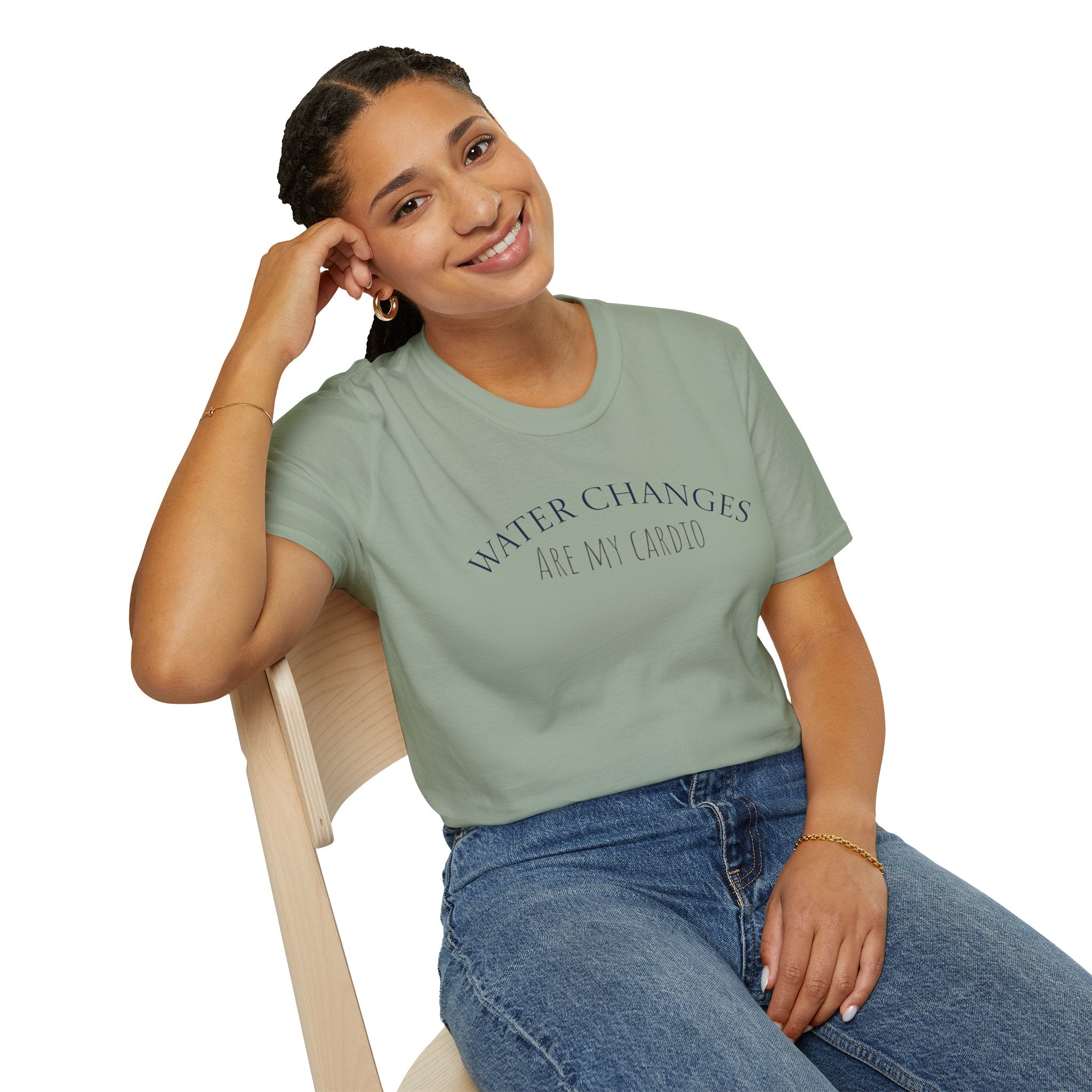 Woman seated wearing green “Water Changes Are My Cardio” shirt, white background